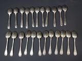 eight silver spoons are arranged in a row on a black surface