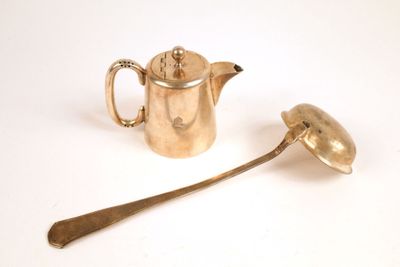 une théière et une cuillère posées l'une à côté de l'autre