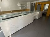 a large kitchen with a marble counter top and yellow walls
