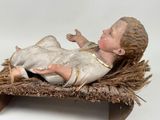 a figurine of a baby jesus in a manger