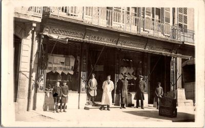 de nombreuses personnes debout devant un magasin, dans la rue