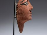 a close up of a sculpture of a head on a stand