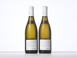 two bottles of white wine sitting next to each other on a table