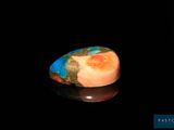 une image d'une bague ornée d'une pierre bleue et orange