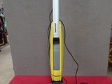 un aspirateur jaune et noir posé sur une table rouge