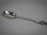 cuillère en argent avec un manche, posée sur une surface blanche