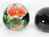 four glass eggs with different designs are lined up on a white surface