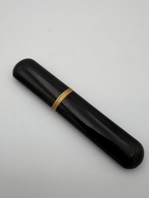 un gros plan d'un stylo noir orné d'une bague dorée