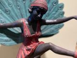 a figurine of a woman with a peacock wings