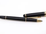deux stylos à plume noirs et dorés posés sur une surface blanche