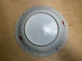 a white plate with red spots on it on a table