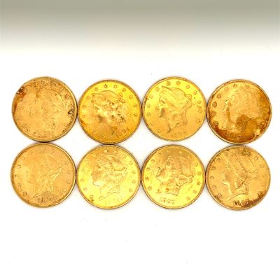 six pièces d'or sont disposées en ligne sur une surface blanche