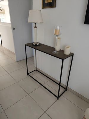 une photo d'un salon avec une table et une lampe