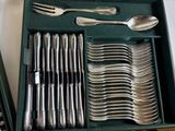 a green box with silverware in it on a table