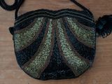 a black purse with a tassel on a wooden table