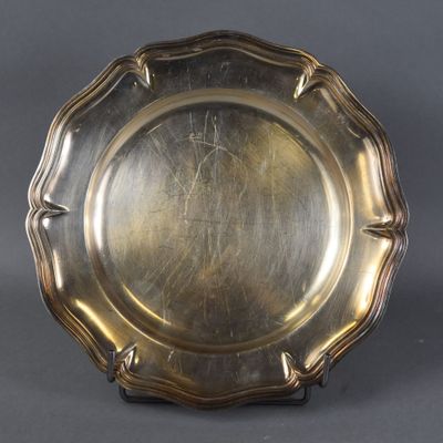 a silver plate on a stand on a grey background