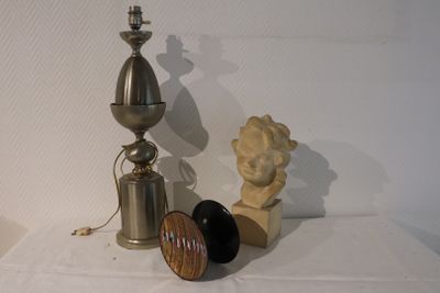 a lamp, a candle holder, and a statue on a table