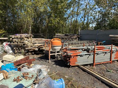 un tas de bois posé par terre à côté d'une clôture