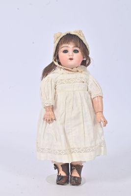 une poupée à l'ancienne, coiffée d'un bonnet et vêtue d'une robe, posée sur un fond blanc