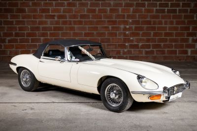 a white and black car parked in front of a brick wall