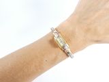 someone is wearing a gold bracelet with a diamond on it