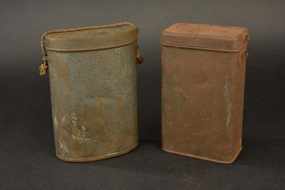 two old tins sitting next to each other on a table