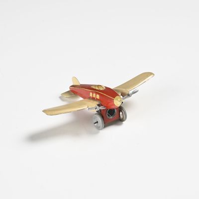un petit avion miniature posé sur une surface blanche