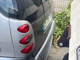 a small car parked next to a curb with a sign on it