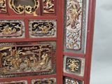 a red and gold screen with carvings on it