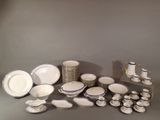 beaucoup d'assiettes et de tasses blanches et bleues sur la table