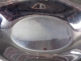 a silver plate with a silver handle on a table