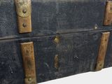 an old black suitcase with brass handles on a white background