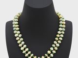 un collier de perles vertes et blanches sur un mannequin