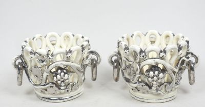 une paire de vases en argent ornés de fleurs sur un fond blanc