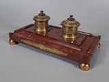 une image représentant un ensemble de bureau rouge et or, orné de deux bougies