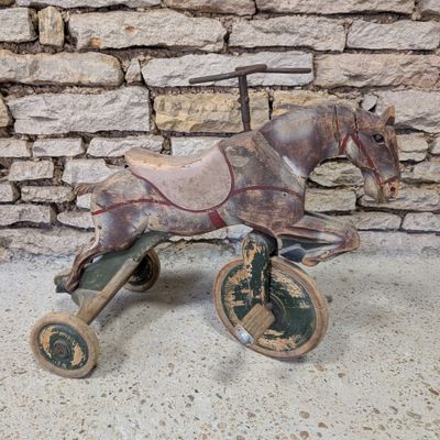 a wooden toy horse that is sitting on top of a cart