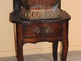a wooden chair with a metal bowl on top of it