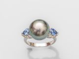 une bague ornée d'une perle noire et d'un saphir bleu sur fond blanc