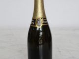 bottle of champagne on a marble countertop with a white wall in the background