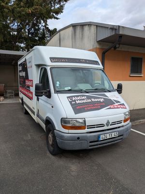 une camionnette blanche garée sur un parking à côté d'un bâtiment