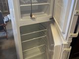 a white refrigerator with its door open in a room