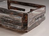 a clear glass box with a wooden handle on a table