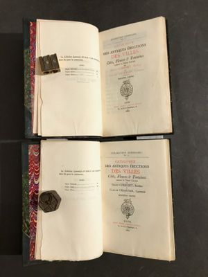 trois livres ouverts posés sur une table, sur fond noir