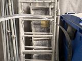 une pile de chaises et une poubelle bleue dans une pièce