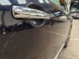 a close up of a car door handle on a black car