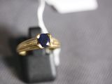an image of a gold ring with a blue stone