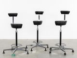 three black stools sitting on top of each other in a room