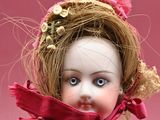 a close up of a doll wearing a red scarf