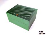 une boîte verte posée sur une surface blanche