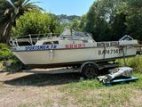 un bateau posé sur une remorque dans l'herbe